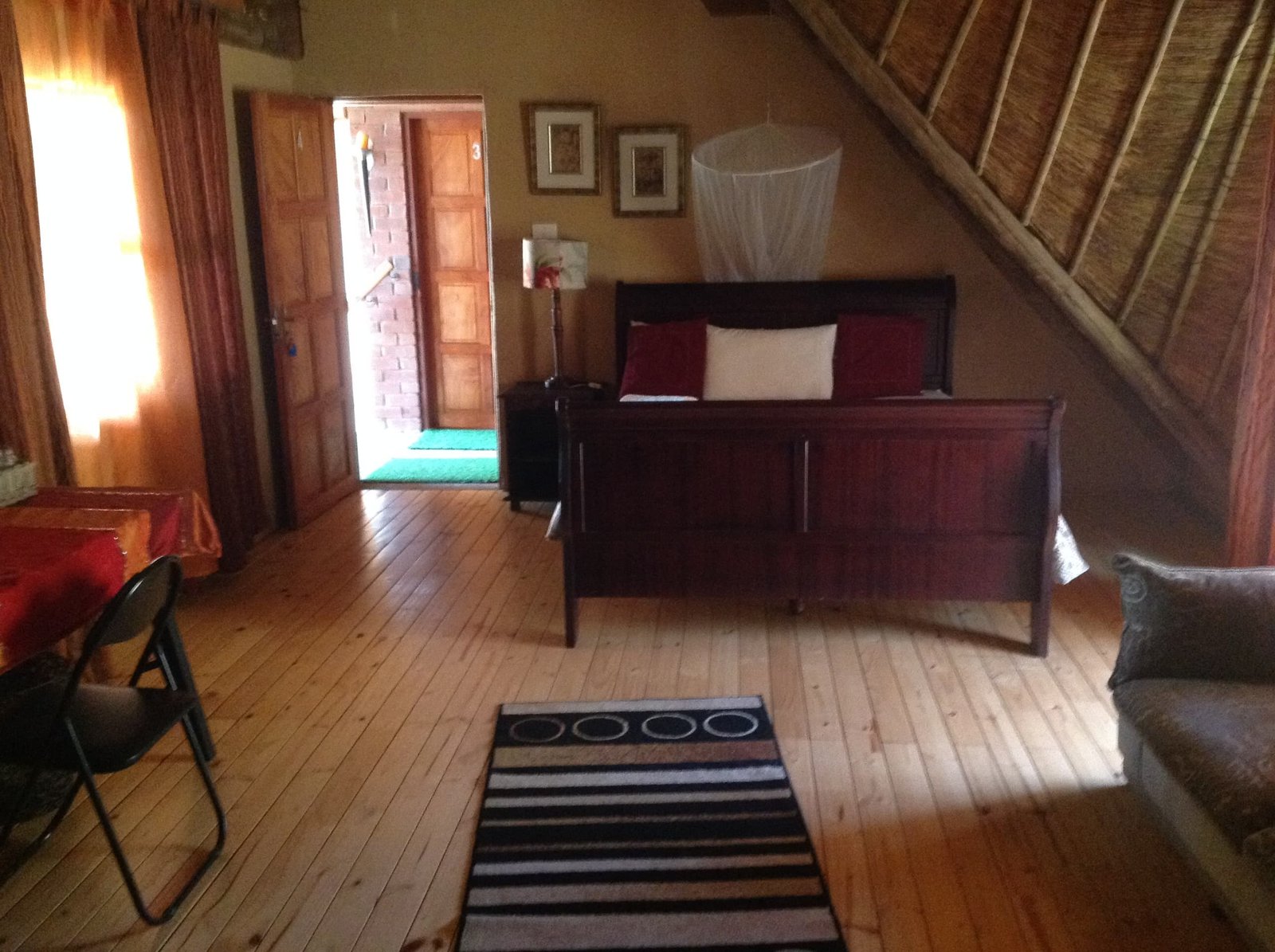 En-suite room with a sleigh bed and mosquito net