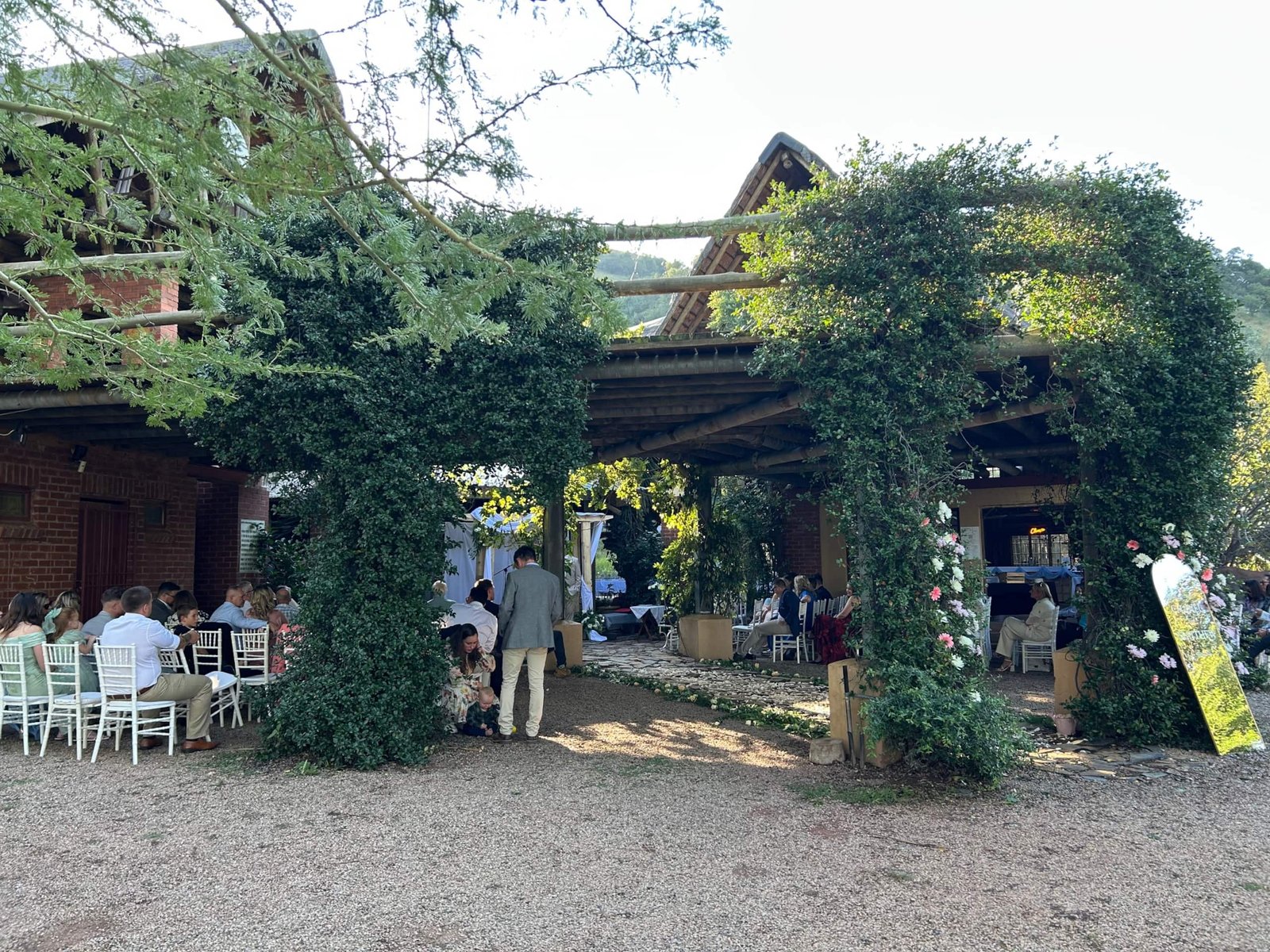 Vine-covered arch with function guests at Sparrow Hawk Lodge