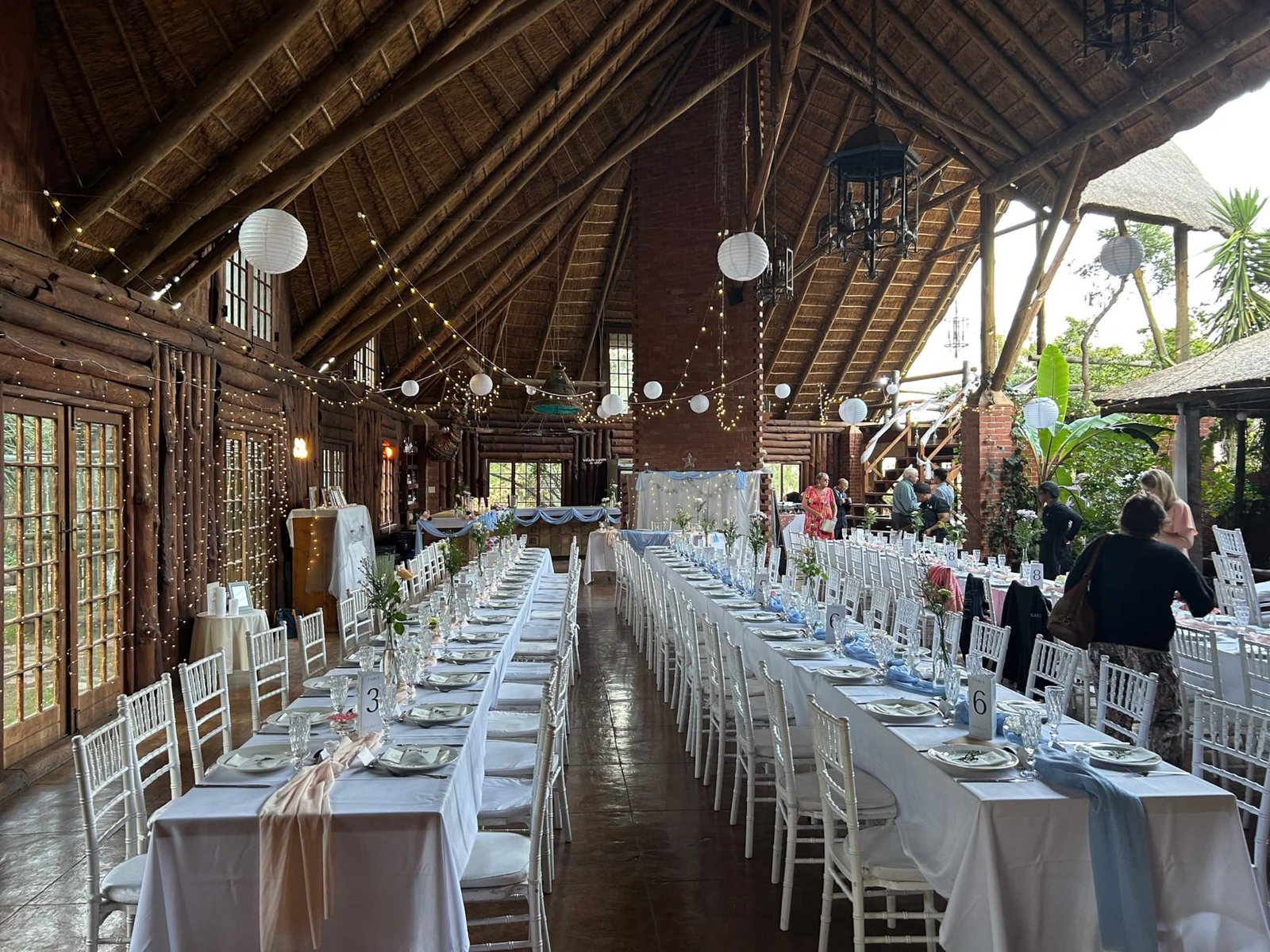 The thatched hall set with long tables for a wedding