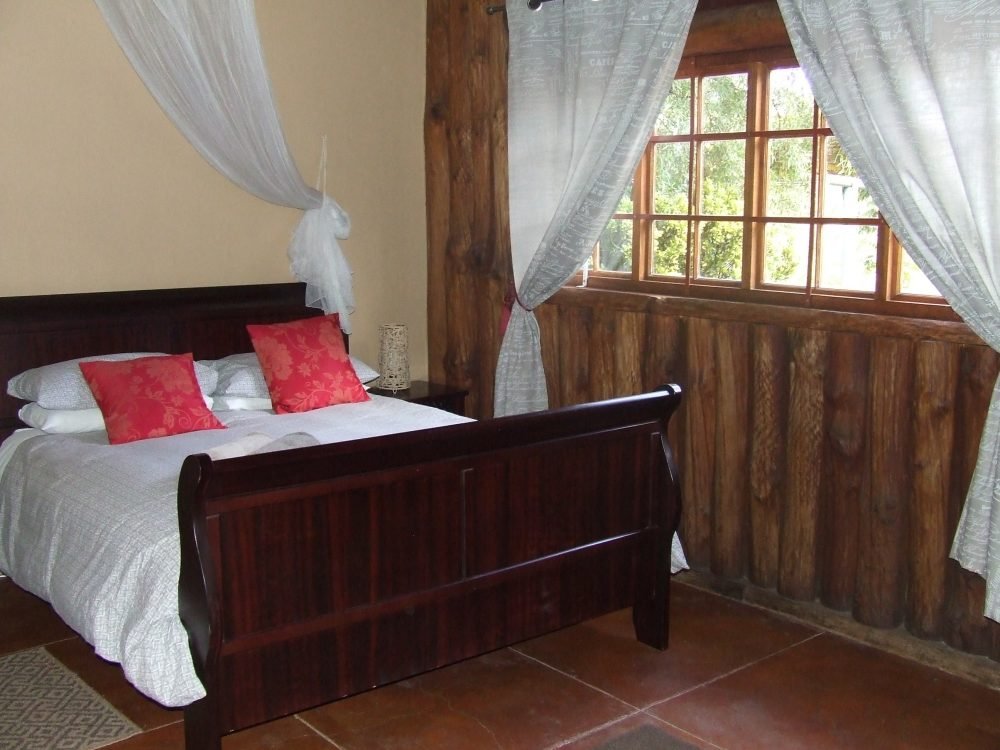 Sleigh bed with mosquito nets and red cushions